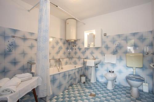 bagno piastrellato blu con vasca e servizi igienici di Apartment Zeljko 34 a Pola (Pula)