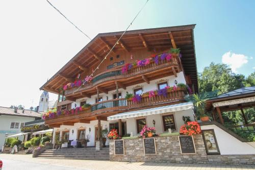a building with balconies and flowers on it at Hotel Metzgerwirt in Fieberbrunn
