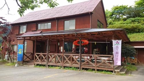 a brown building with a sign in front of it at Gokase Campsite Camping and Guesthouse in Gokase