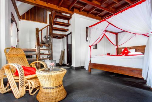 1 dormitorio con 1 cama y sillas de mimbre en EcoTravel Cottages Bukit Lawang, en Bukit Lawang