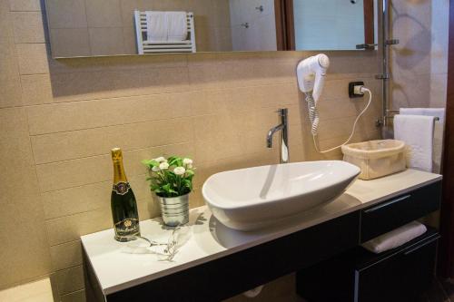 a bathroom with a sink and a bottle of champagne at Hotel San Clemente in Santarcangelo di Romagna