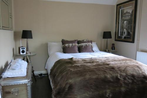 Un dormitorio con una cama grande con una manta. en The Old Dairy Malvern en Great Malvern