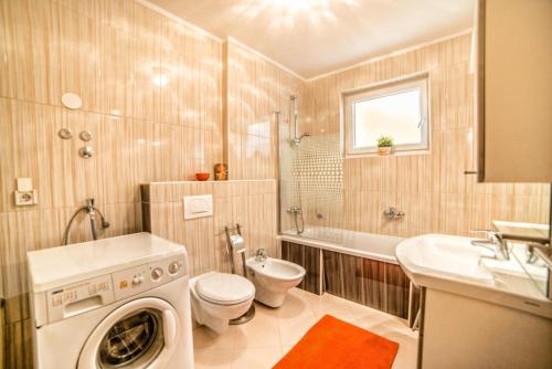 bagno con lavatrice, servizi igienici e lavandino di Apartments Creska 629 a Rabac