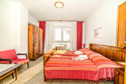 una camera da letto con due letti, una sedia e una finestra di Apartments Creska 629 a Rabac