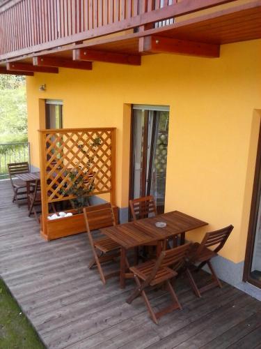 a wooden deck with a wooden table and chairs at Apartments Maligoj in Tolmin