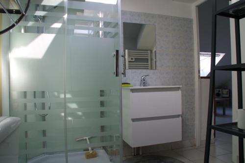 a bathroom with a glass shower and a sink at L'annexe in Étaples