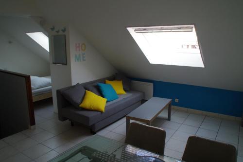 un soggiorno con divano e cuscini gialli e blu di L'annexe a Étaples