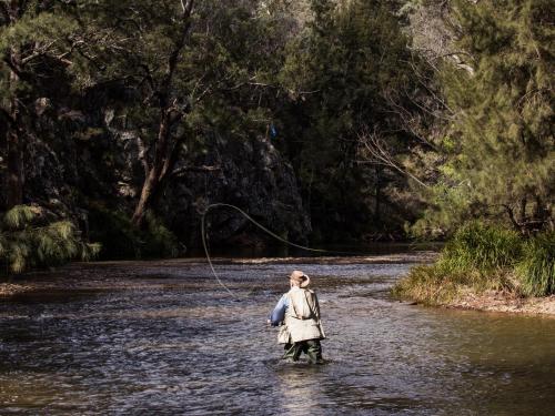 a woman is standing in a river holding a string at Turon Gates - Mountain Retreat in Capertee