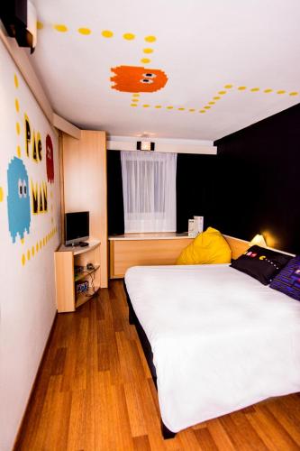a bedroom with a large white bed and a television at Ibis Poznan Stare Miasto in Poznań