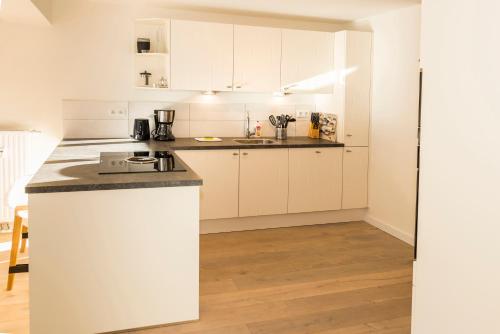 a kitchen with white cabinets and a counter top at Kristall Plaza in Niederau