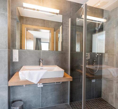 a bathroom with a sink and a shower at Kristall Plaza in Niederau