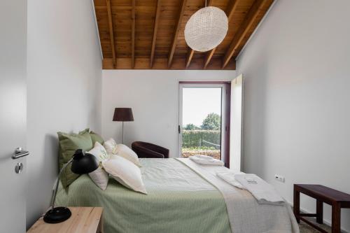 a bedroom with a bed with a table and a window at Quinta da Tilia Boutique Retreat in Capelas