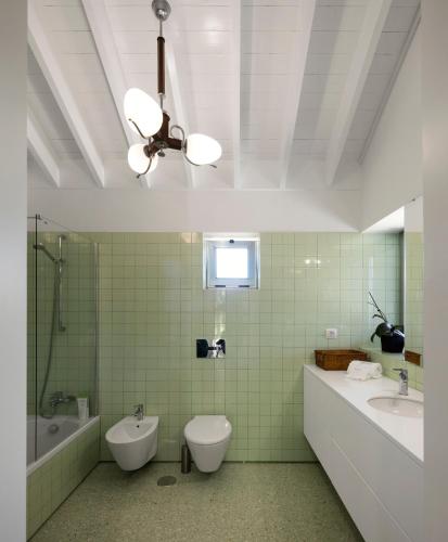 a bathroom with a toilet and a tub and a sink at Quinta da Tilia Boutique Retreat in Capelas