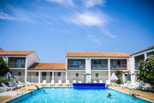 una piscina di fronte a un hotel di Village Vacances Passion Ré La Blanche a Le Bois-Plage-en-Ré