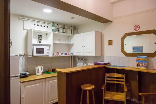 a kitchen with a sink, stove, microwave and refrigerator at Tempi Hotel in Athens