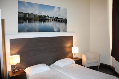 a bedroom with a bed with a painting above it at Hotel Sansa in Maastricht