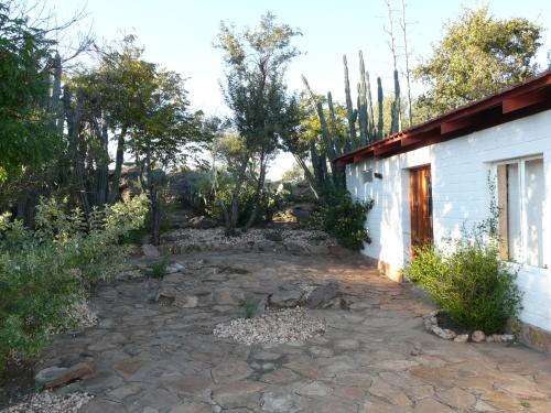 a patio outside of a white building with trees at Halala Africa Lodge - Eagle Rock Lodge in Malabar