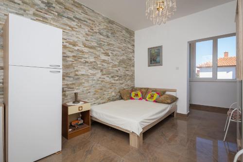 - une chambre avec un lit et un mur en briques dans l'établissement ALBA Amazing Location Beach Apartments, à Biograd na Moru