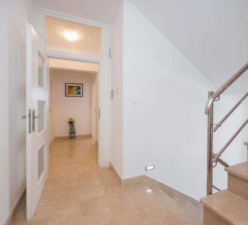 un couloir avec un escalier et un mur blanc dans l'établissement ALBA Amazing Location Beach Apartments, à Biograd na Moru