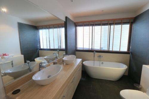 y un baño grande con 4 lavabos y 2 lavabos. en Naiharn Beach Villa en Nai Harn Beach