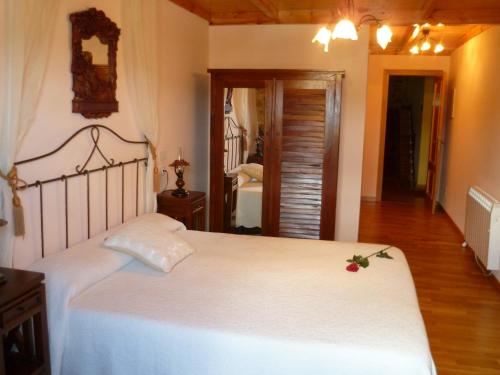 a bedroom with a large white bed in a room at Casal de Cereixo in Tufiones