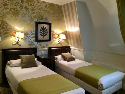 Una habitación de hotel con dos camas y dos lámparas. en Elysees Apartments, en París