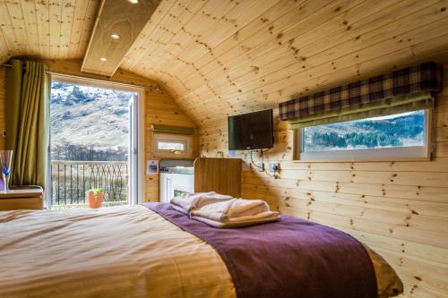 a bedroom with a bed and a tv in a room at Heart of Glencoe Holidays in Glencoe