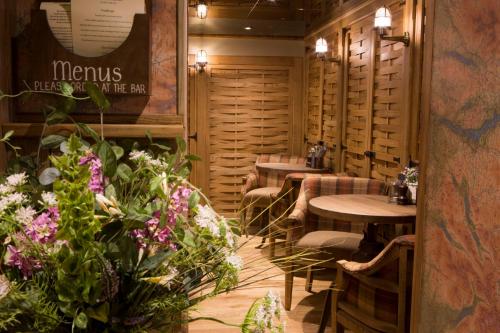 a restaurant with tables and chairs and flowers at The Queen's Head Hotel in Troutbeck