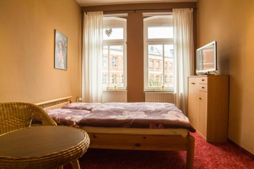 a bedroom with a bed and a chair and a window at Ferienwohnung Wandelt in Arnstadt