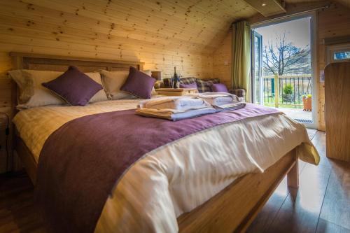 a bedroom with a large bed in a wooden room at Heart of Glencoe Holidays in Glencoe