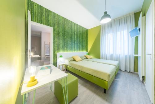 a hotel room with two beds and a table with a desk at Hotel La Diga Altomincio in Valeggio sul Mincio