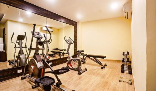 a gym with several exercise bikes and a mirror at Souvenir Jaipur in Jaipur