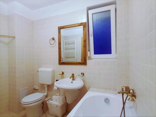 a bathroom with a sink and a toilet and a mirror at Voyage Residence in Mamaia