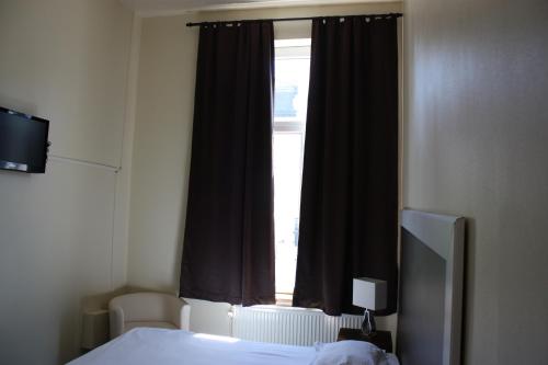a bedroom with a bed and a window at Hotel Sansa in Maastricht
