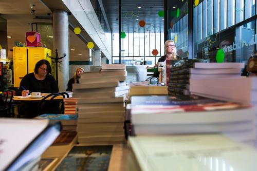 a group of people sitting at tables in a book store at Student Hostel in Reykjavík