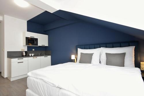 ein Schlafzimmer mit einem großen Bett mit blauer Wand in der Unterkunft Alveo Suites in Prag