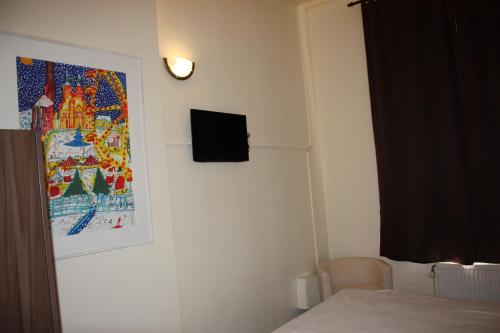 a room with a bed and a picture on the wall at Hotel Sansa in Maastricht