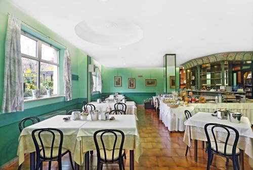 a restaurant with white tables and chairs in a room at Hotel Residence Sogno in Novara