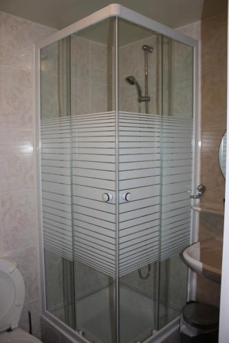 a shower with a glass enclosure in a bathroom at Hotel Sansa in Maastricht