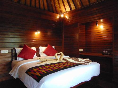 een slaapkamer met een bed met rode kussens bij Starfish Lembongan in Nusa Lembongan