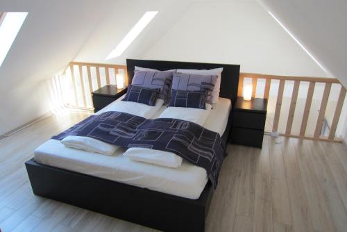 a bedroom with a large bed with purple pillows at Appartement Mezzanine in Hévíz