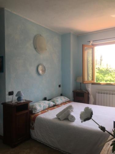 a bedroom with a bed and a window at Agriturismo LA TAVERNA DEL NONNO in Borzonasca