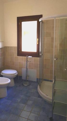 a bathroom with a toilet and a glass shower at Casa Bithia in Chia