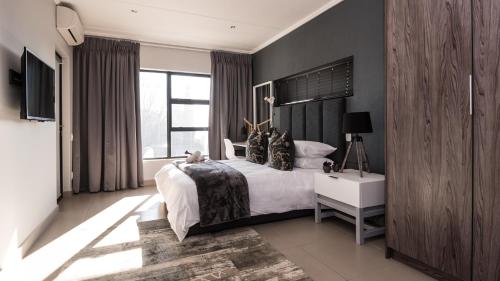 Johannesburg的住宿－Odyssey Luxury Apartments - Back Up Generator，一间卧室设有一张大床和一个大窗户