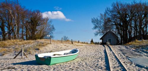 a boat sitting on the sand next to a barn at Hotel-Marks-Garni in Zingst