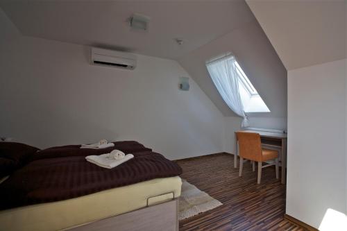 a bedroom with a bed and a desk and a window at Pútnický mlyn in Marianka