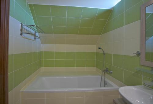 a bathroom with a bath tub and a sink at Pútnický mlyn in Marianka
