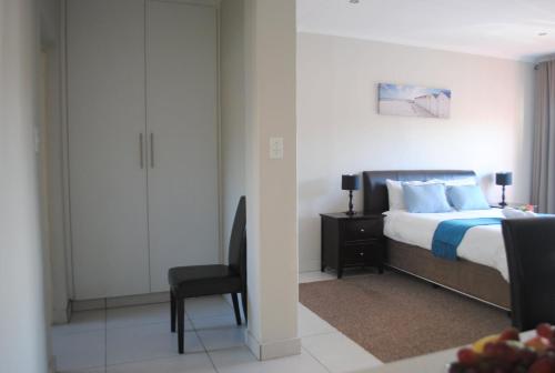 Un dormitorio con una cama, un escritorio y una silla. en 86 Edison Self Catering, en Johannesburgo
