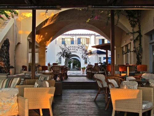 a restaurant with chairs and tables and an archway at Levante Beach Hotel in Kamari