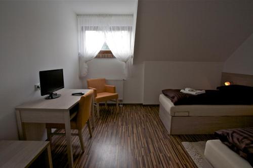 a small room with a bed and a desk with a computer at Pútnický mlyn in Marianka
